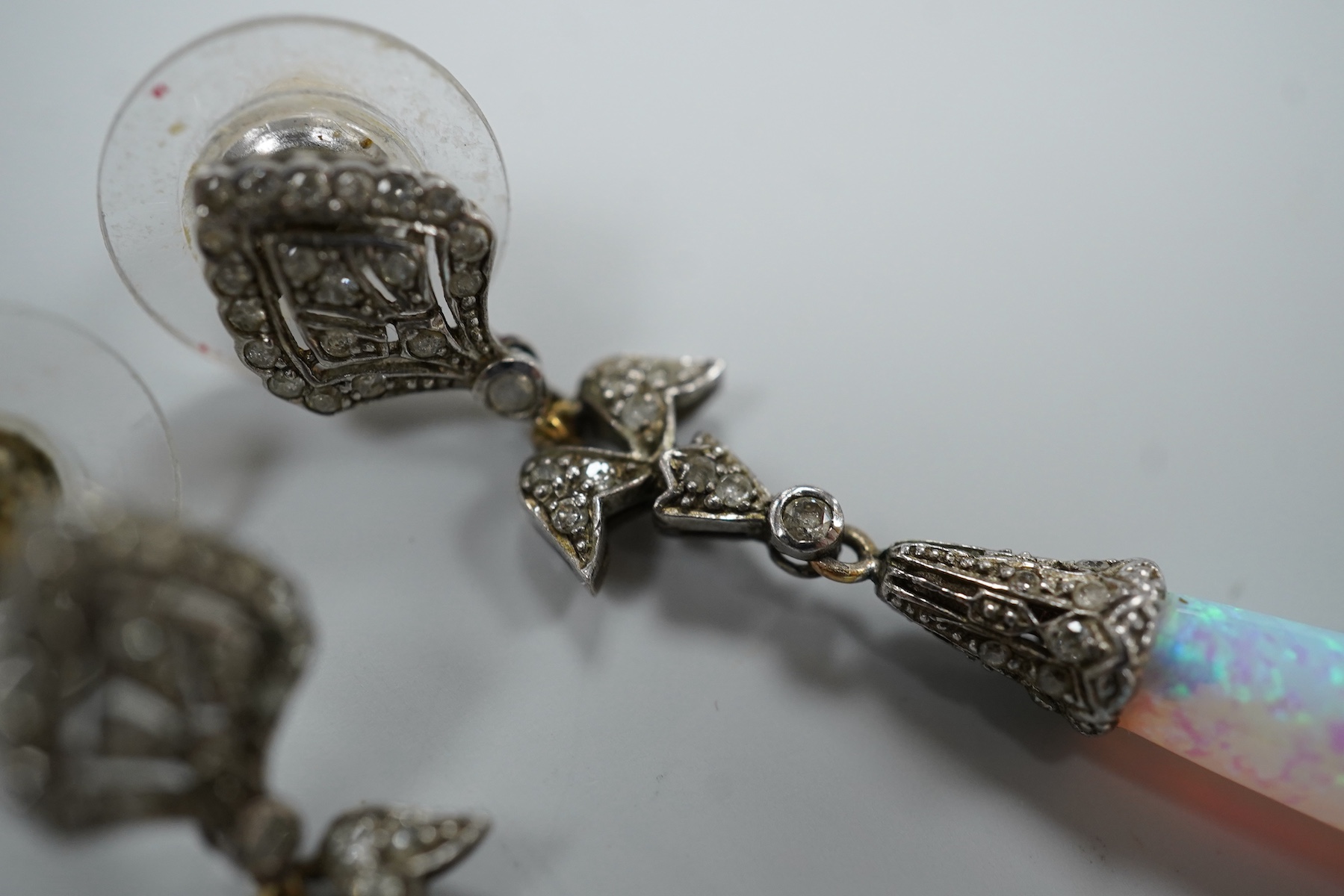 A pair of 1920's style white metal, synthetic opal and diamond chip set drop earrings, 63mm, gross weight 8.2 grams.